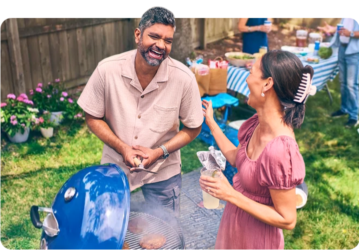Un hombre y una mujer se ríen en una divertida barbacoa.